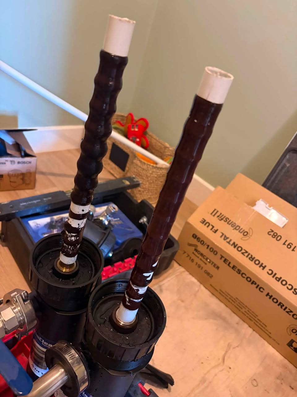 Two magnetic filter cartridges pulled out, both coated in thick black iron sludge.